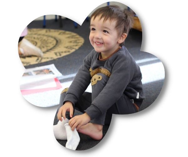 Young boy putting on his socks at The Children's Corner childcare centre in Howick, Auckland (1)